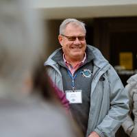 man smiling in front of the fieldhouse